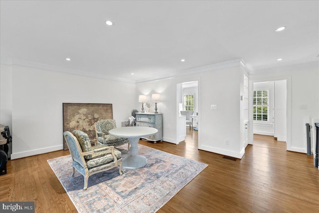 living area featuring ornamental molding, wood finished floors, and visible vents
