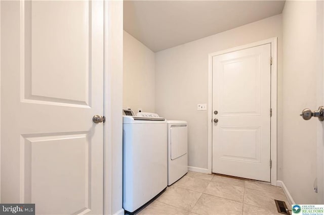 laundry area featuring laundry area, light tile patterned floors, baseboards, and washer and clothes dryer