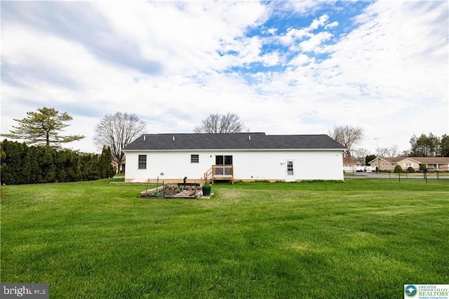 rear view of property featuring a yard
