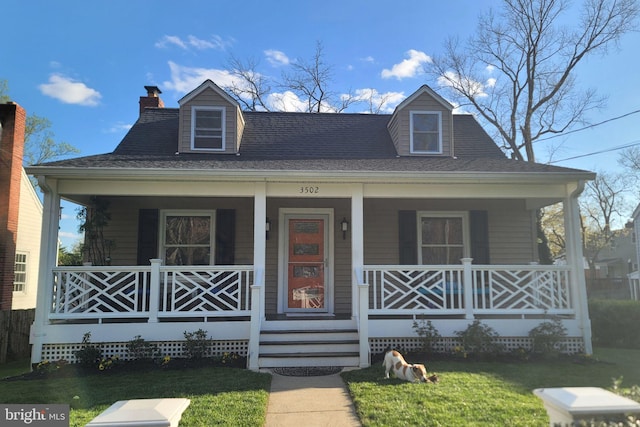 view of front of property with a front lawn, covered porch, and a chimney
