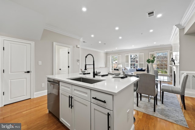 kitchen with recessed lighting, light countertops, dishwasher, a sink, and crown molding