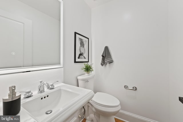half bath featuring vanity and toilet