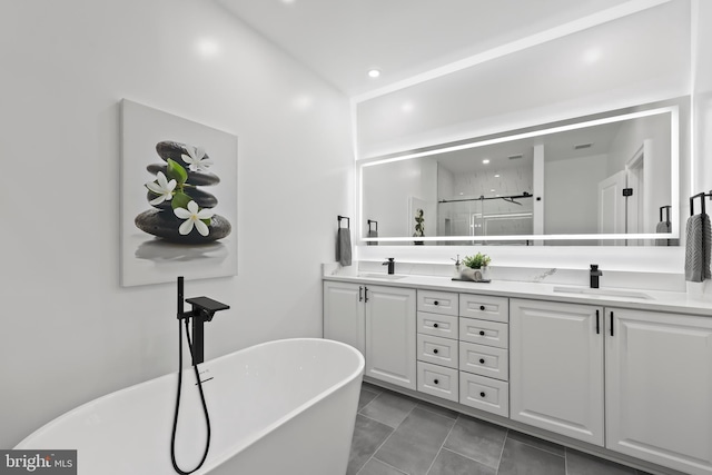 bathroom featuring a shower stall, double vanity, a soaking tub, and a sink