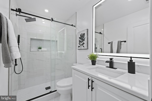 bathroom featuring marble finish floor, toilet, vanity, and a marble finish shower
