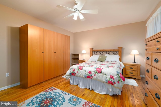 bedroom with wood-type flooring, a ceiling fan, and baseboards