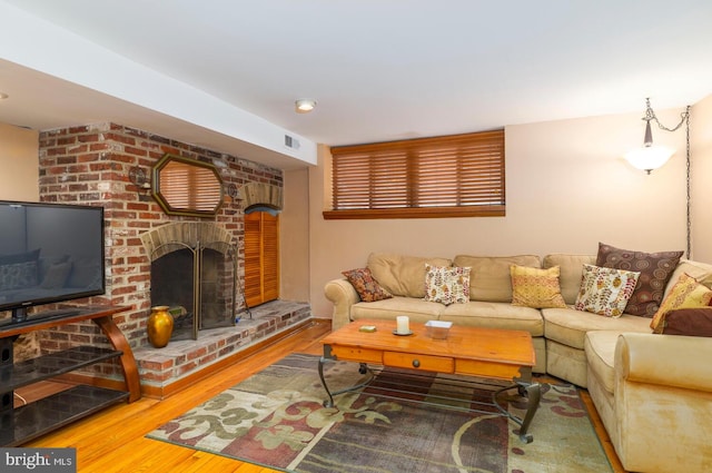 living room with visible vents, wood finished floors, and a fireplace