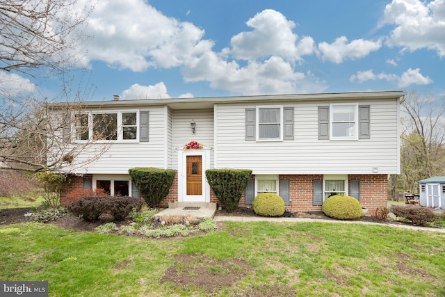 raised ranch with a front lawn and brick siding
