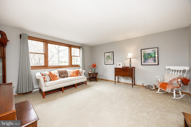 living area featuring a baseboard heating unit, carpet, and baseboards