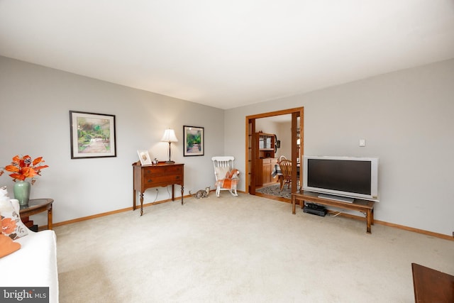 sitting room with baseboards and carpet