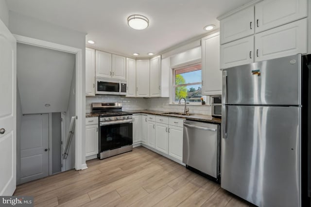 6 Walnut Dr, Burlington, NJ 08016 - kitchen with a sink, dark countertops, white cabinetry, decorative backsplash, and appliances with stainless steel finishes