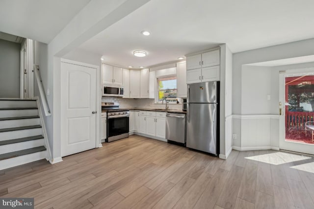 6 Walnut Dr, Burlington, NJ 08016 - kitchen with a sink, wainscoting, stainless steel appliances, light wood-style flooring, and white cabinets