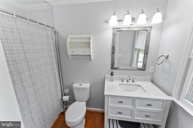 bathroom with vanity, toilet, baseboards, wood finished floors, and ornamental molding