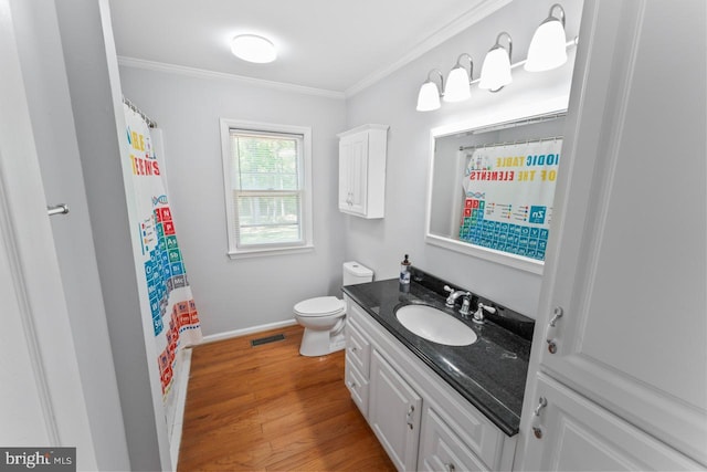 bathroom featuring crown molding, vanity, toilet, wood finished floors, and visible vents