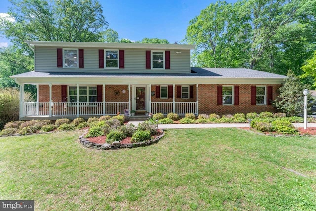 view of front of house featuring a porch, brick siding, and a front yard