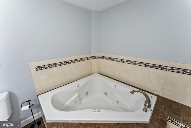 full bath featuring toilet and a whirlpool tub