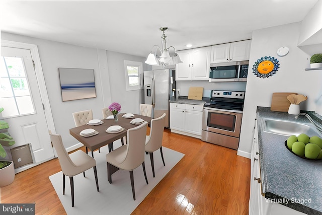 kitchen with white cabinets, stainless steel appliances, and dark countertops