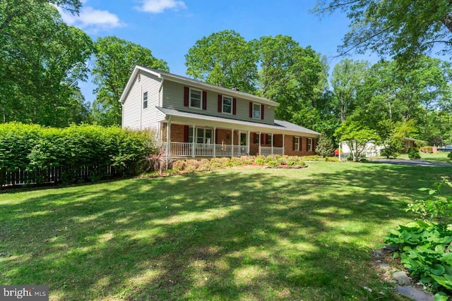 farmhouse featuring a porch, a front lawn, and brick siding