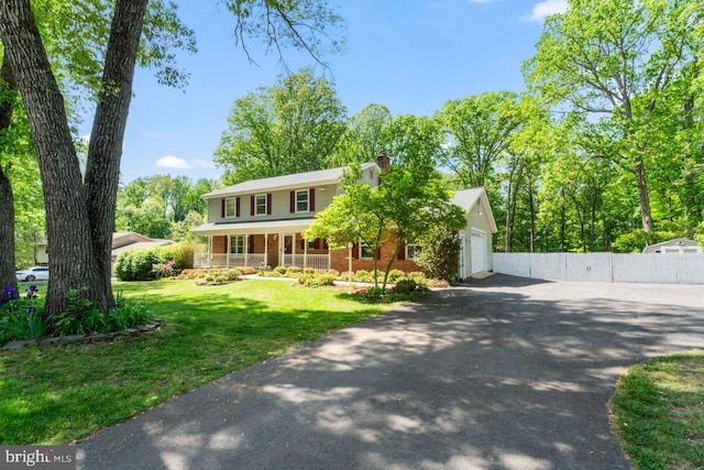 view of front of property featuring fence, a garage, a chimney, covered porch, and driveway