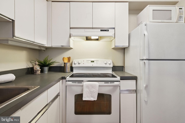kitchen featuring white cabinetry, under cabinet range hood, dark countertops, and white appliances