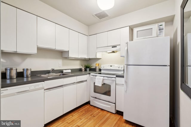 kitchen featuring white appliances, white cabinetry, visible vents, under cabinet range hood, and a sink