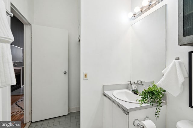 half bath with tile patterned floors, toilet, and vanity