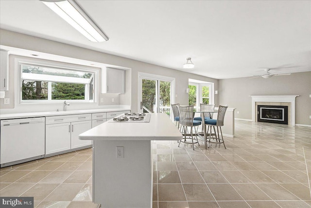 5342 Saint James Pl, Frederick, MD 21703 - kitchen with light tile patterned floors, light countertops, a fireplace, white appliances, and a ceiling fan