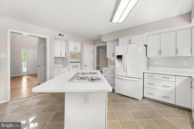 5342 Saint James Pl, Frederick, MD 21703 - kitchen with white cabinetry, visible vents, light countertops, a center island, and white appliances