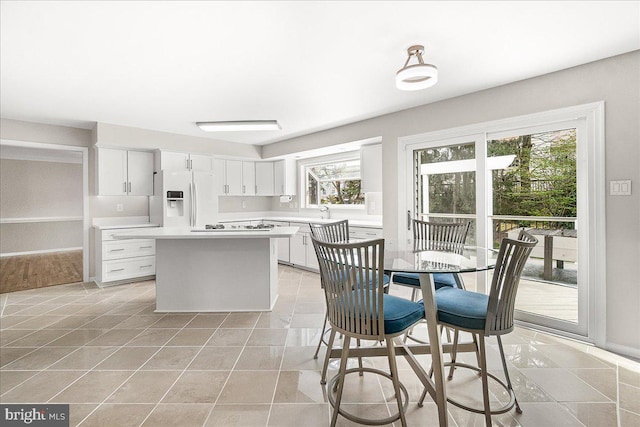 5342 Saint James Pl, Frederick, MD 21703 - kitchen featuring white appliances, light countertops, white cabinets, a center island, and light tile patterned flooring