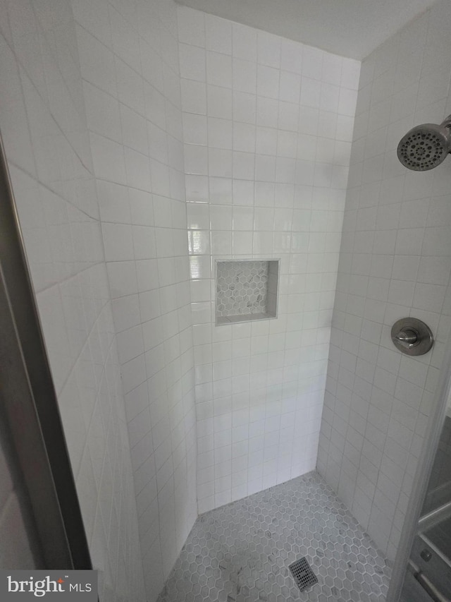 full bath featuring tile patterned floors and a shower stall