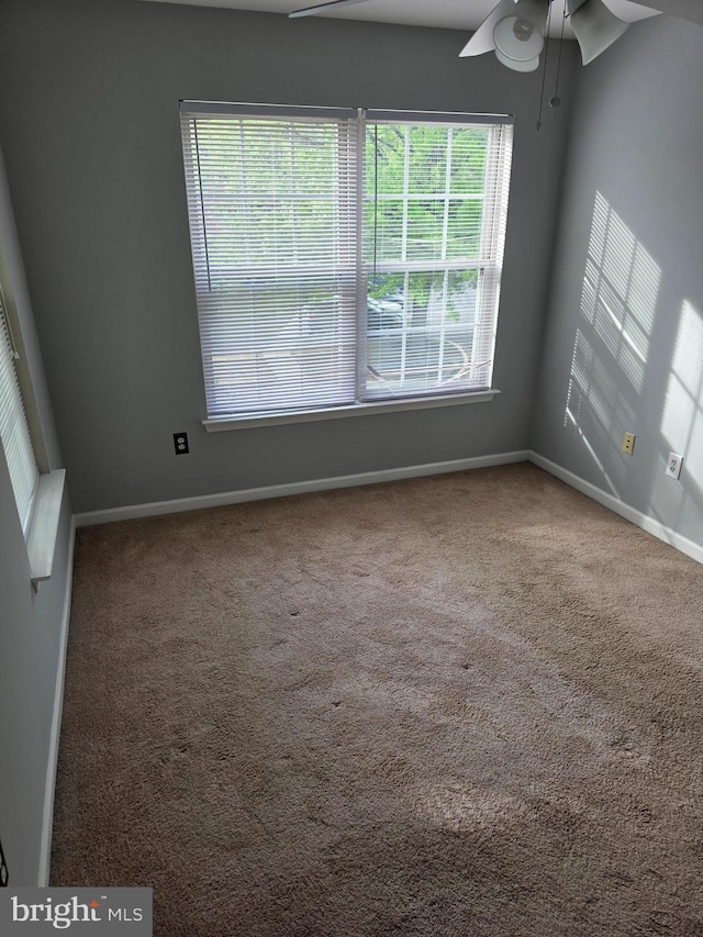 unfurnished room with carpet, a ceiling fan, and baseboards