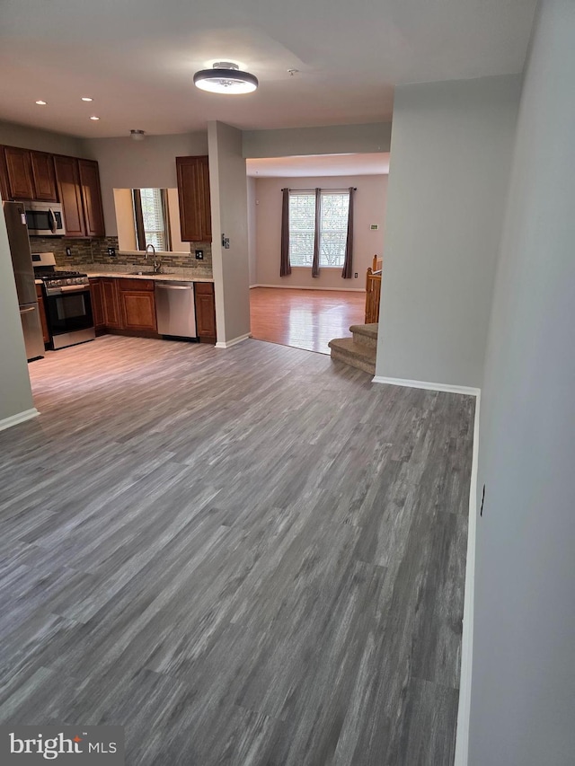 kitchen with light wood-style flooring, a healthy amount of sunlight, open floor plan, and stainless steel appliances
