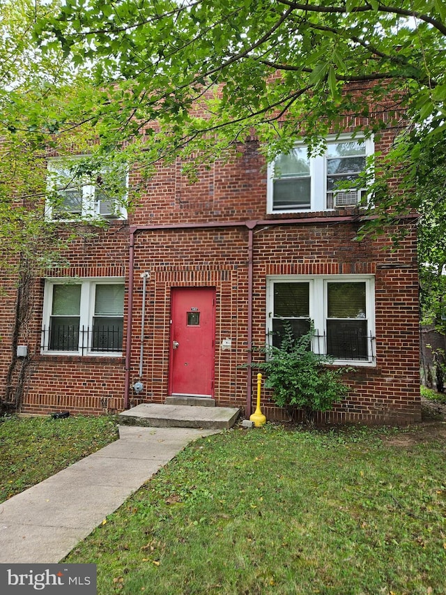 multi unit property featuring brick siding and a front yard