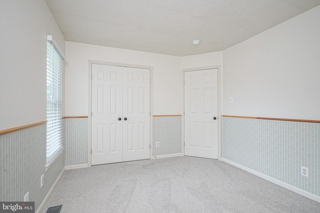 619 Walden Way, Lumberton, NJ 08048 - unfurnished bedroom featuring wainscoting, multiple windows, carpet flooring, a closet, and a textured ceiling