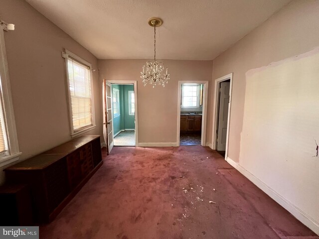 721 Tuckerman St NW, Washington, DC 20011 - unfurnished dining area featuring carpet flooring, a notable chandelier, and baseboards