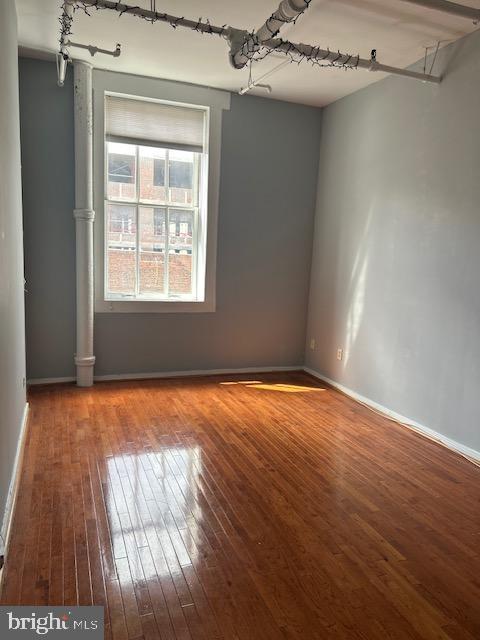 empty room featuring hardwood / wood-style floors and baseboards