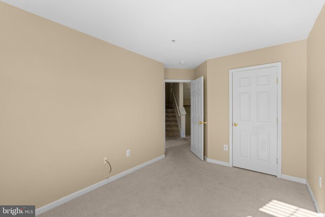 unfurnished bedroom with light carpet and baseboards