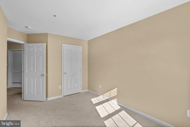 unfurnished bedroom featuring carpet floors and baseboards