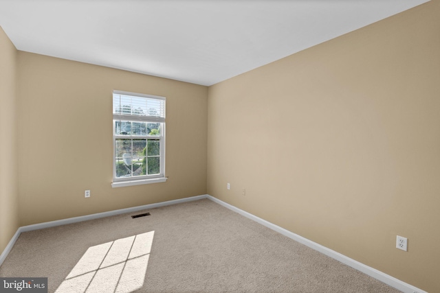 unfurnished room featuring visible vents, baseboards, and carpet
