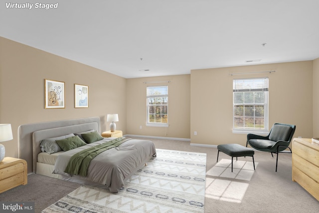 carpeted bedroom with visible vents and baseboards