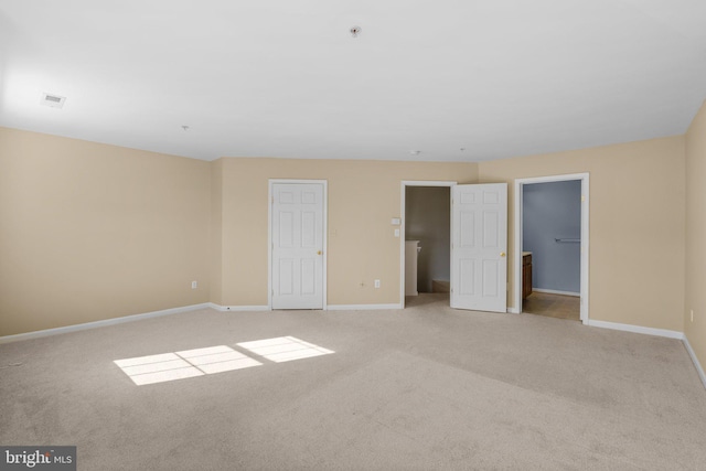 unfurnished bedroom with baseboards and light colored carpet