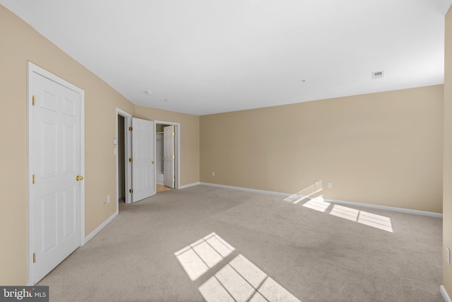 interior space with light colored carpet, baseboards, and visible vents