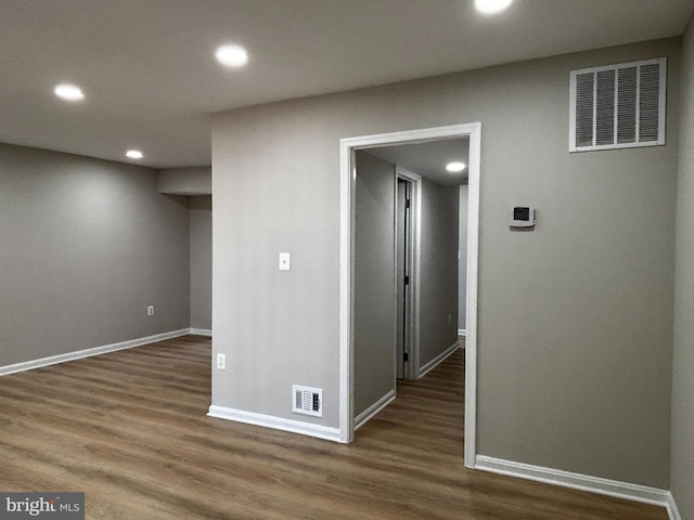 basement featuring wood finished floors, visible vents, and baseboards