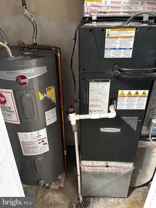 utility room featuring heating unit and electric water heater