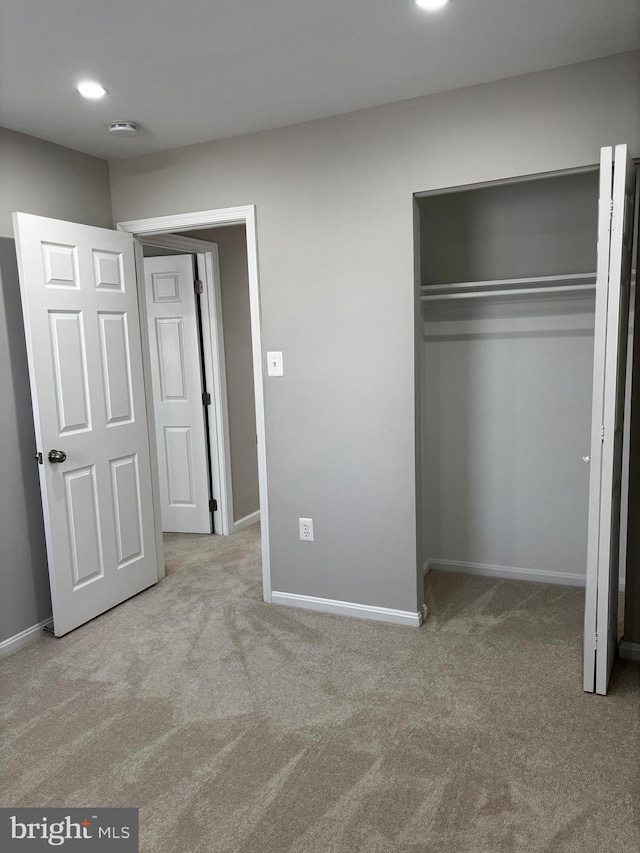 unfurnished bedroom featuring recessed lighting, a closet, carpet flooring, and baseboards