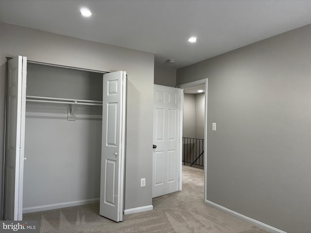 unfurnished bedroom with recessed lighting, a closet, carpet flooring, and baseboards