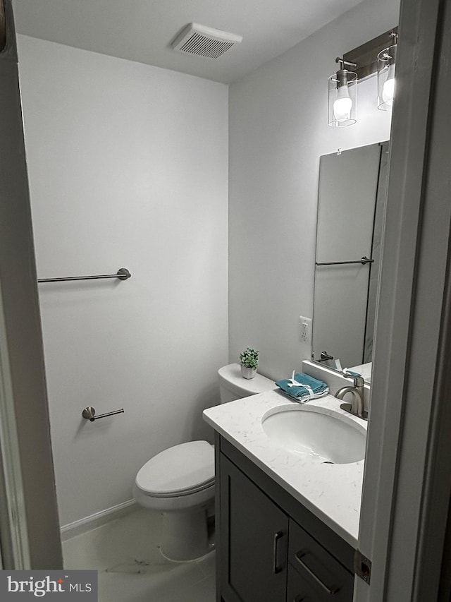 bathroom with toilet, baseboards, visible vents, marble finish floor, and vanity