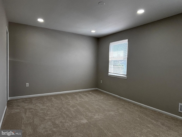 carpeted empty room featuring baseboards and recessed lighting