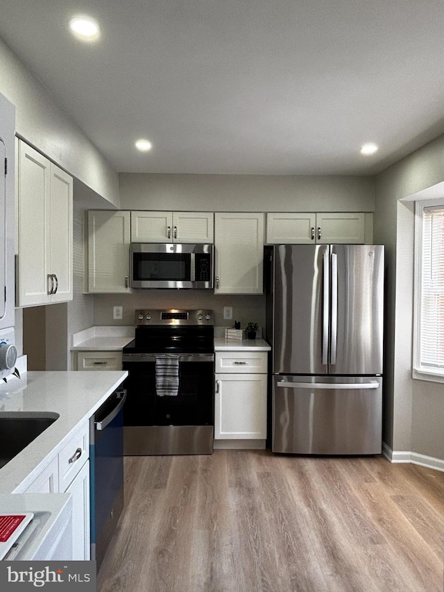 kitchen featuring light countertops, recessed lighting, appliances with stainless steel finishes, and light wood-style flooring