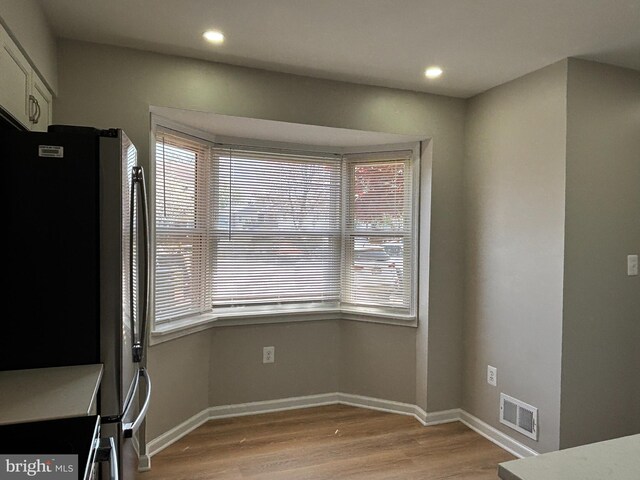 unfurnished dining area featuring recessed lighting, light wood-style flooring, visible vents, and baseboards