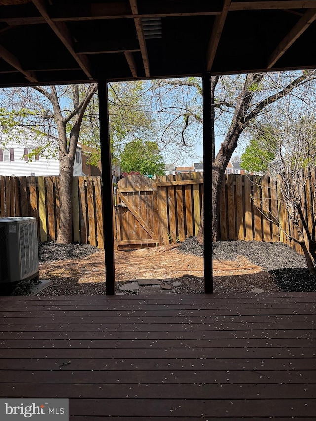 deck with central AC and a fenced backyard
